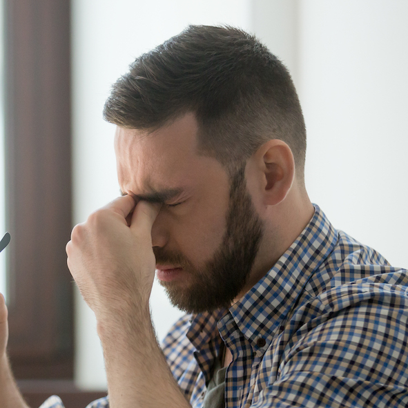 Stressed male massaging nose bridge suffering from headache SRS-Hair-Loss-Treatment